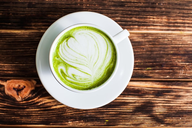 Vista dall'alto della tazza Matcha latte su fondo in legno. Il concetto di tè verde come arte