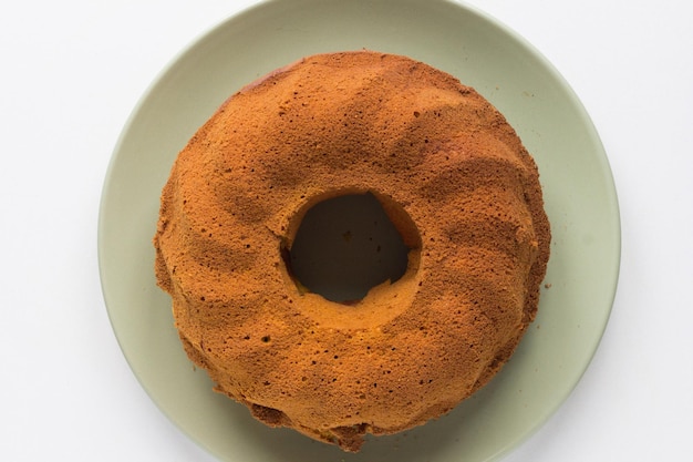 Vista dall'alto della torta di zucca al forno sul piatto verde su sfondo bianco