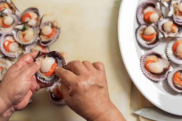 Vista dall'alto delle mani di un cuoco che preimposta i frutti di mare su un piatto