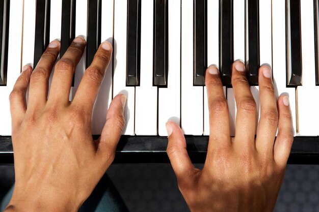 vista dall'alto delle mani femminili che suonano il pianoforte