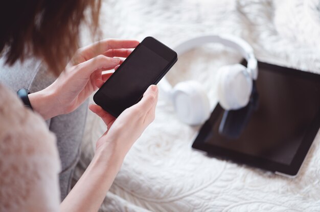 Vista dall'alto delle mani femminili che tengono smartphone moderno