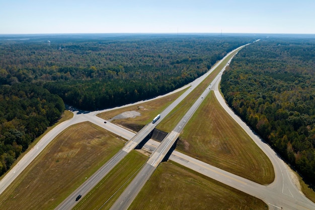 Vista dall'alto dello svincolo di uscita dell'autostrada su corsie stradali con auto e camion in rapido movimento Infrastrutture di trasporto interstatali negli Stati Uniti