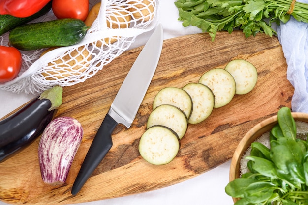 Vista dall'alto di affettare verdure melanzane pepe spinaci insalata processo di preparazione cena casalinga