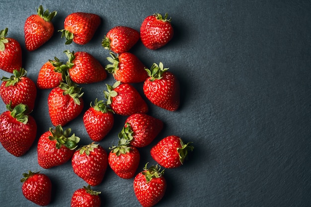 Vista dall'alto di alcune fragole rosse sul buio