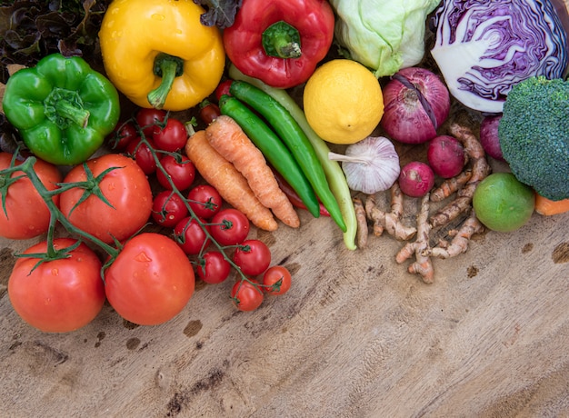 Vista dall'alto di alimenti biologici su tavola di legno, composizione con verdure organiche crude assortite