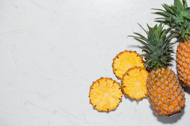 Vista dall'alto di ananas fresco a fette su uno sfondo di marmo.