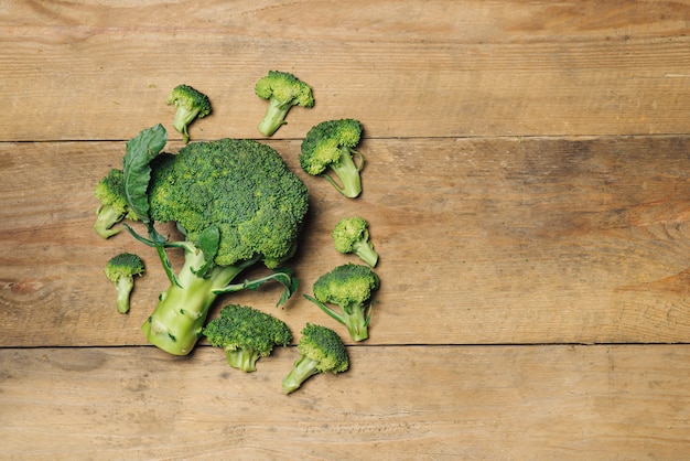 Vista dall'alto di broccoli verdi freschi su fondo di legno rustico - cibo sano o vegetariano.