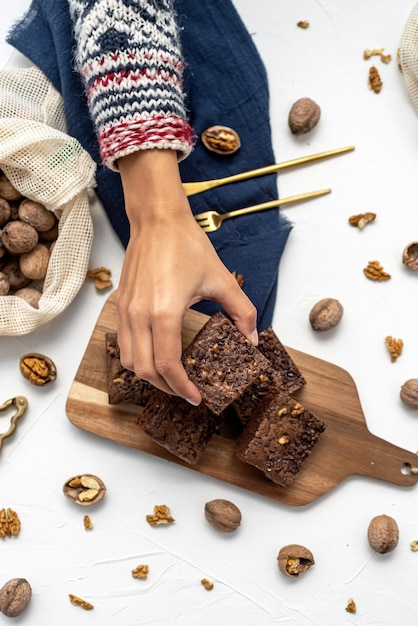 Vista dall'alto di brownies impilati e noci su sfondo bianco