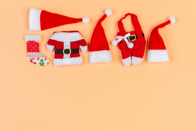 Vista dall'alto di cappelli e vestiti rossi di Babbo Natale su sfondo colorato. Buon Natale concetto con copia spazio.