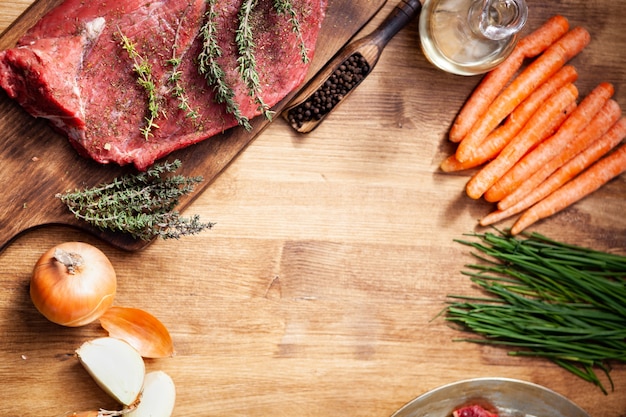 Vista dall'alto di carne cruda e ingredienti sani per barbecue su tavola di legno. Verdure gustose. Cibo organico.