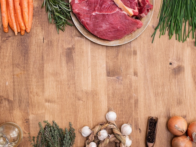 Vista dall'alto di carne cruda e verdure pronte per essere cotte. Copia spazio disponibile.