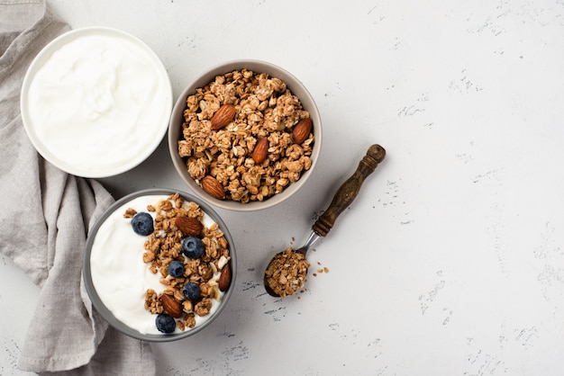 Vista dall'alto di ciotole con cereali per la colazione e yogurt