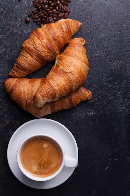 Vista dall'alto di croissant tradizionali con caffè caldo. Cornetti d'oro.