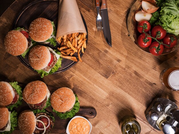 Vista dall'alto di diversi hamburger e birra sul tavolo della ristorazione. Copia spazio disponibile.