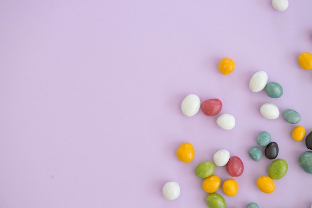 Vista dall'alto di dolci colorati su sfondo viola con spazio per la copia