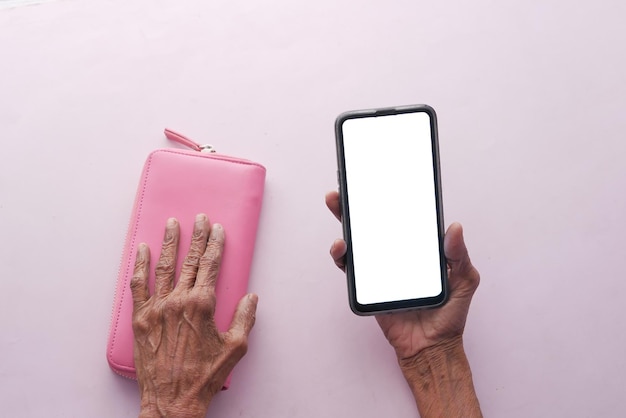 Vista dall'alto di donne anziane che tengono uno smartphone con schermo vuoto