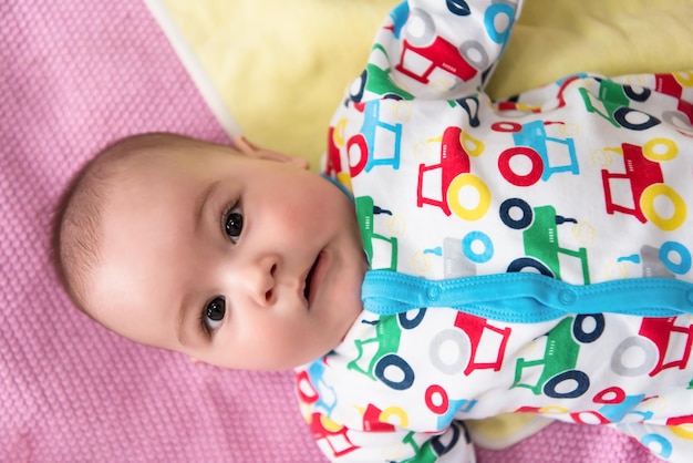 vista dall'alto di felice bellissimo neonato sdraiato su coperte colorate mentre giocava per i primi giochi a casa