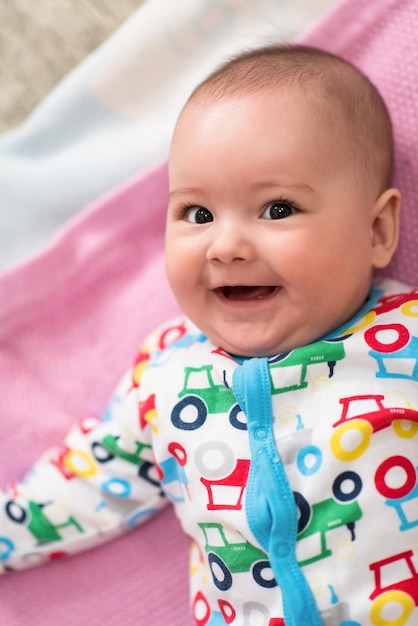 vista dall'alto di felice bellissimo neonato sdraiato su coperte colorate mentre giocava per i primi giochi a casa