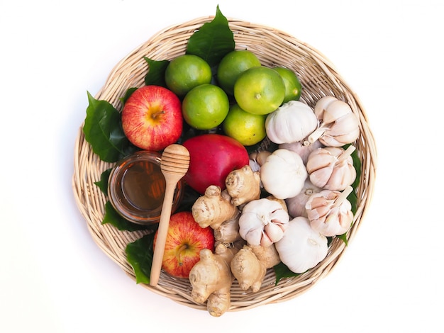 Vista dall'alto di frutta e verdura nel cesto di bambù con miele Cibo sano a portata di mano isolato su uno spazio bianco