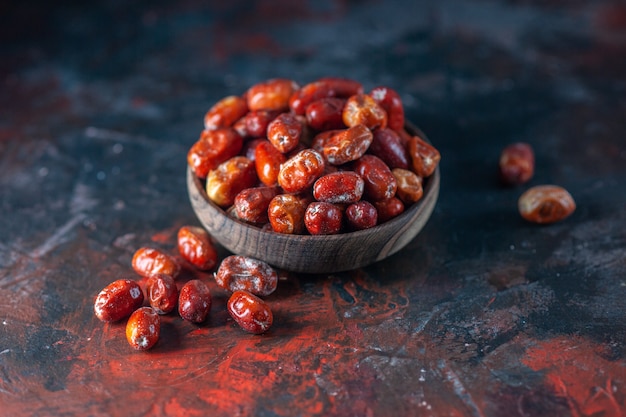 Vista dall'alto di frutti freschi di silverberry crudi all'interno e all'esterno di una ciotola su sfondo di colori misti con spazio libero