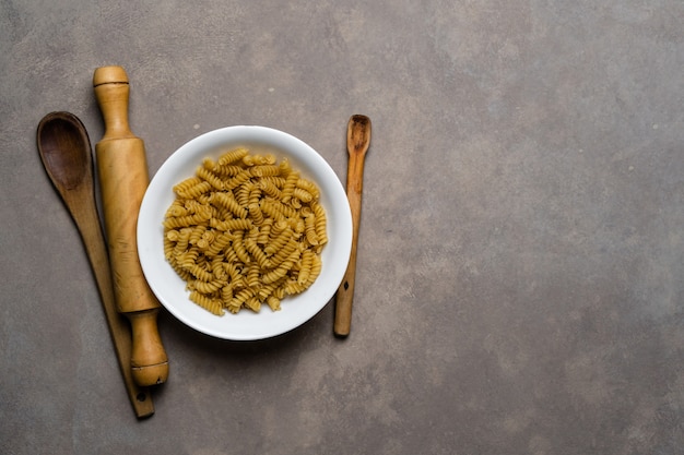 Vista dall'alto di fusilli crudi sulla piastra bianca