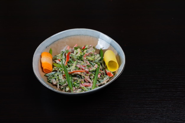 Vista dall'alto di insalata con verdure pollo e maionese su sfondo nero
