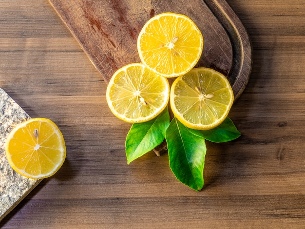 Vista dall'alto di limoni e foglie verdi su superficie di legno