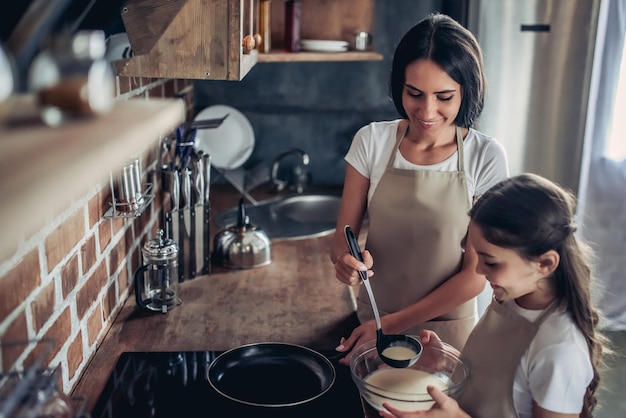 Vista dall'alto di madre e figlia che preparano i pancake in cucina