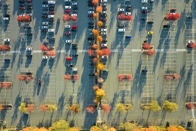 Vista dall'alto di molte auto parcheggiate nel parcheggio con linee e indicazioni per parcheggi e indicazioni Posto per veicoli di fronte a un centro commerciale