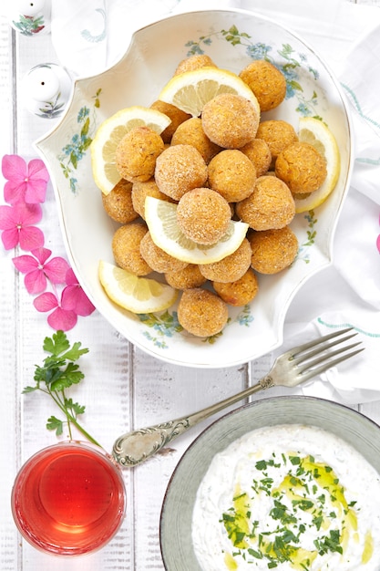 Vista dall&#39;alto di piatto con falafel e salsa di salsa con yogurt, tahine e prezzemolo.