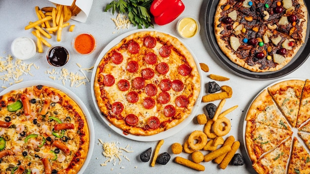 Vista dall'alto di pizze e snack assortiti su un tavolo