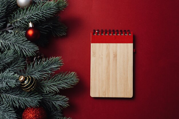 Vista dall'alto di rami di albero di Natale con ornamenti e notebook