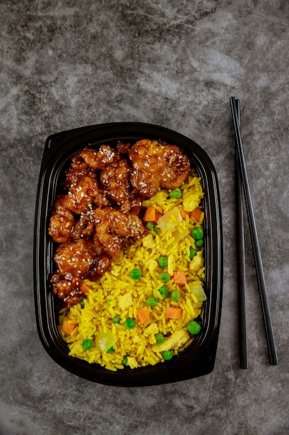 Vista dall'alto di riso fritto e pollo teriyaki con le bacchette. Cibo salutare.