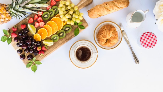 Vista dall&#39;alto di sana colazione con assortimento di frutta, tè e pane