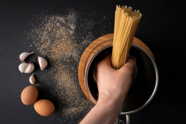 Vista dall&#39;alto di spaghetti duri grezzi in una pentola di metallo, acqua bollente, ingredienti per cucinare i dintorni