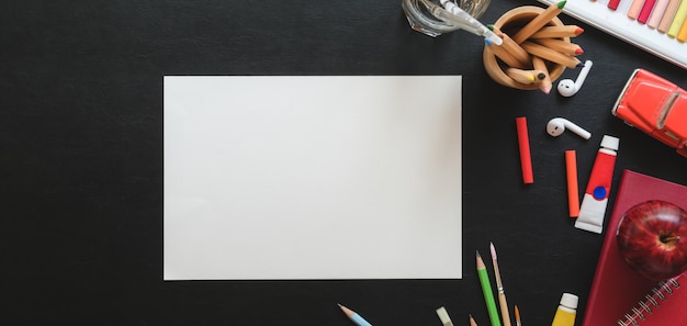 Vista dall'alto di studio artista alla moda con carta da schizzo e strumenti di pittura