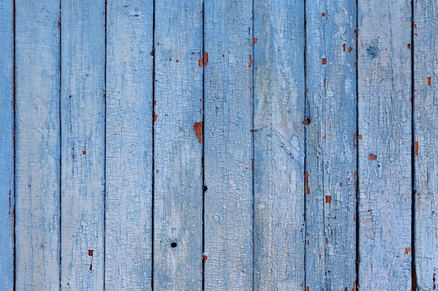 Vista dall'alto di tavole di legno stagionate con vernice blu incrinata.