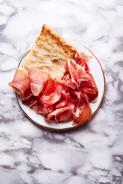 Vista dall'alto di un aperitivo di prosciutto serrano con pane rustico