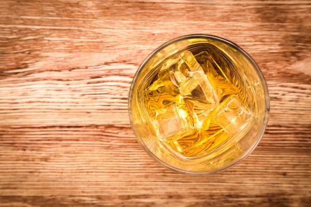 Vista dall'alto di un bicchiere di delizioso whisky sul tavolo di legno