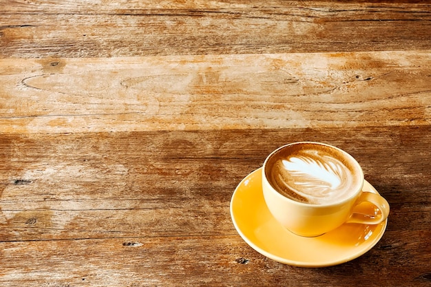 Vista dall'alto di un caffè latte art sul vecchio tavolo di legno