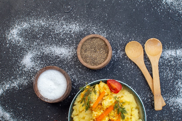 Vista dall'alto di un delizioso pasto a base di patate con cucchiai di spezie di verdure fresche su sfondo bianco nero a colori misti con spazio libero