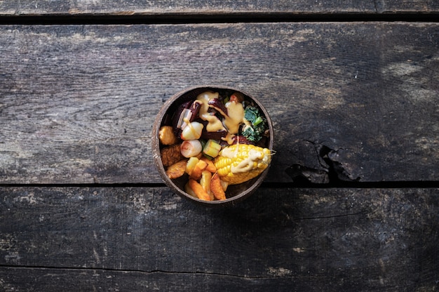 Vista dall'alto di un delizioso pranzo vegano pieno di cereali, verdure e proteine servito in una ciotola di cocco biologico