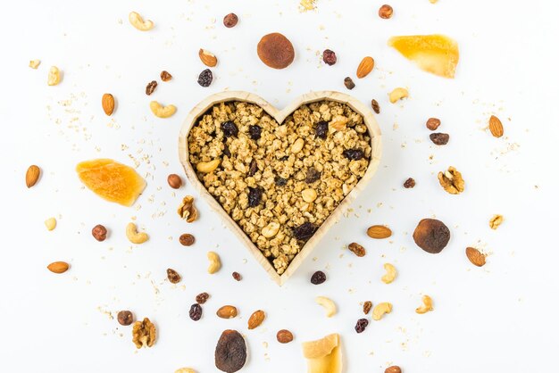 Vista dall'alto di un fiocco a forma di cuore pieno di muesli croccante. Mangiare sano concetto.