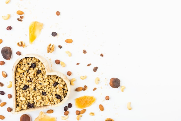 Vista dall'alto di un fiocco a forma di cuore pieno di muesli croccante. Mangiare sano concetto.