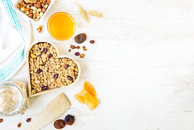 Vista dall'alto di un fiocco a forma di cuore pieno di muesli croccante. Mangiare sano concetto.