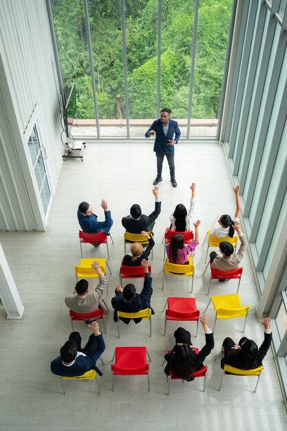 Vista dall'alto di un gruppo di uomini d'affari seduti e che ascoltano una presentazione in una sala conferenze