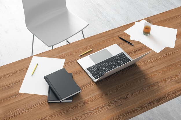 Vista dall'alto di un moderno posto di lavoro con una scrivania in legno e un laptop Rendering 3D