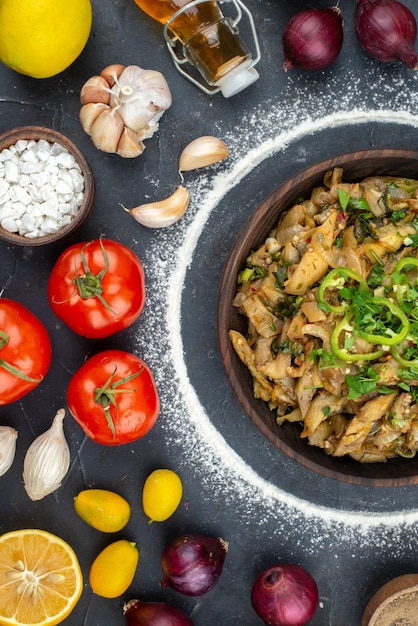 Vista dall'alto di un pasto delizioso tra le uova di bottiglia di olio cadute, verdure fresche, farina, spezie su sfondo nero