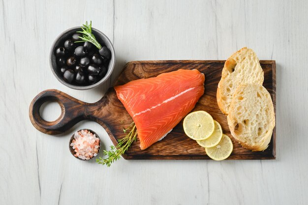 Vista dall'alto di un pezzo di filetto di coda di salmone fresco con ciabatta e salsa piccante alle erbe