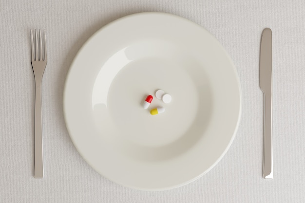 Vista dall'alto di un piatto con le pillole accanto a un coltello e una forchetta su bianco
